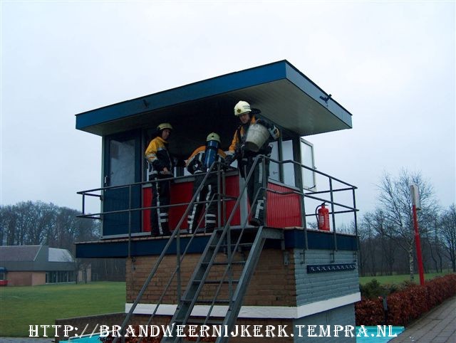 met een emmer wordt water uit het zwembad gehaald